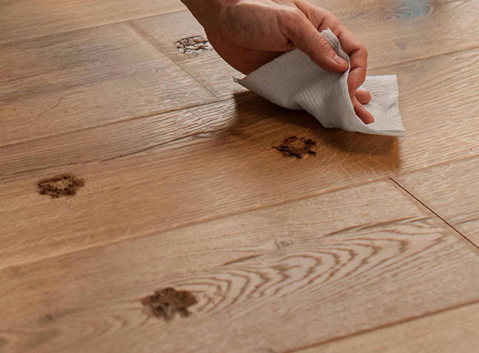 Person using Viva Paper Towels to clean up muddy paw prints from pet